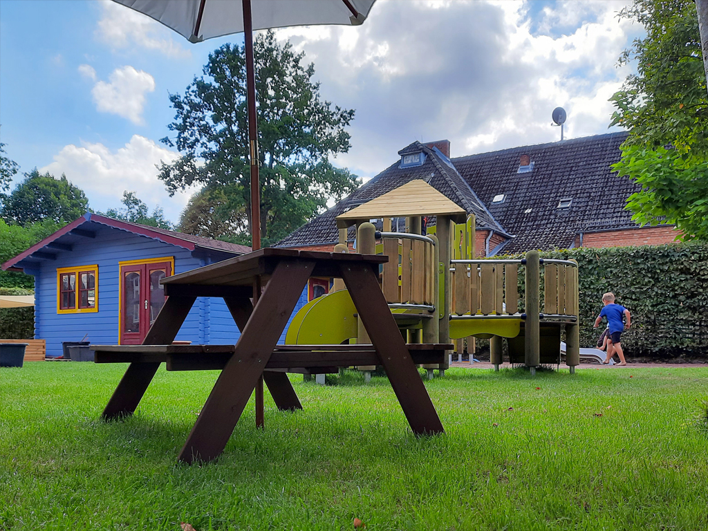 Unser Kita-Garten mit Atelierhäuschen, Klettergerüst und Picknicktisch