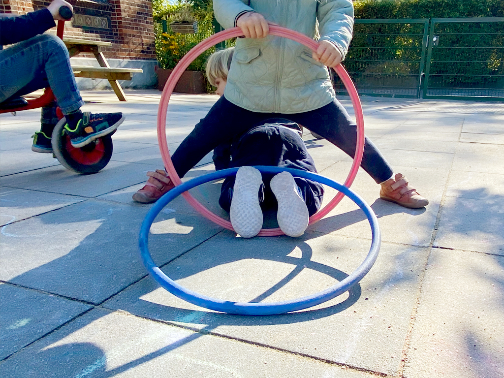 Turnen auf dem Hof mit den Hulahoopreifen